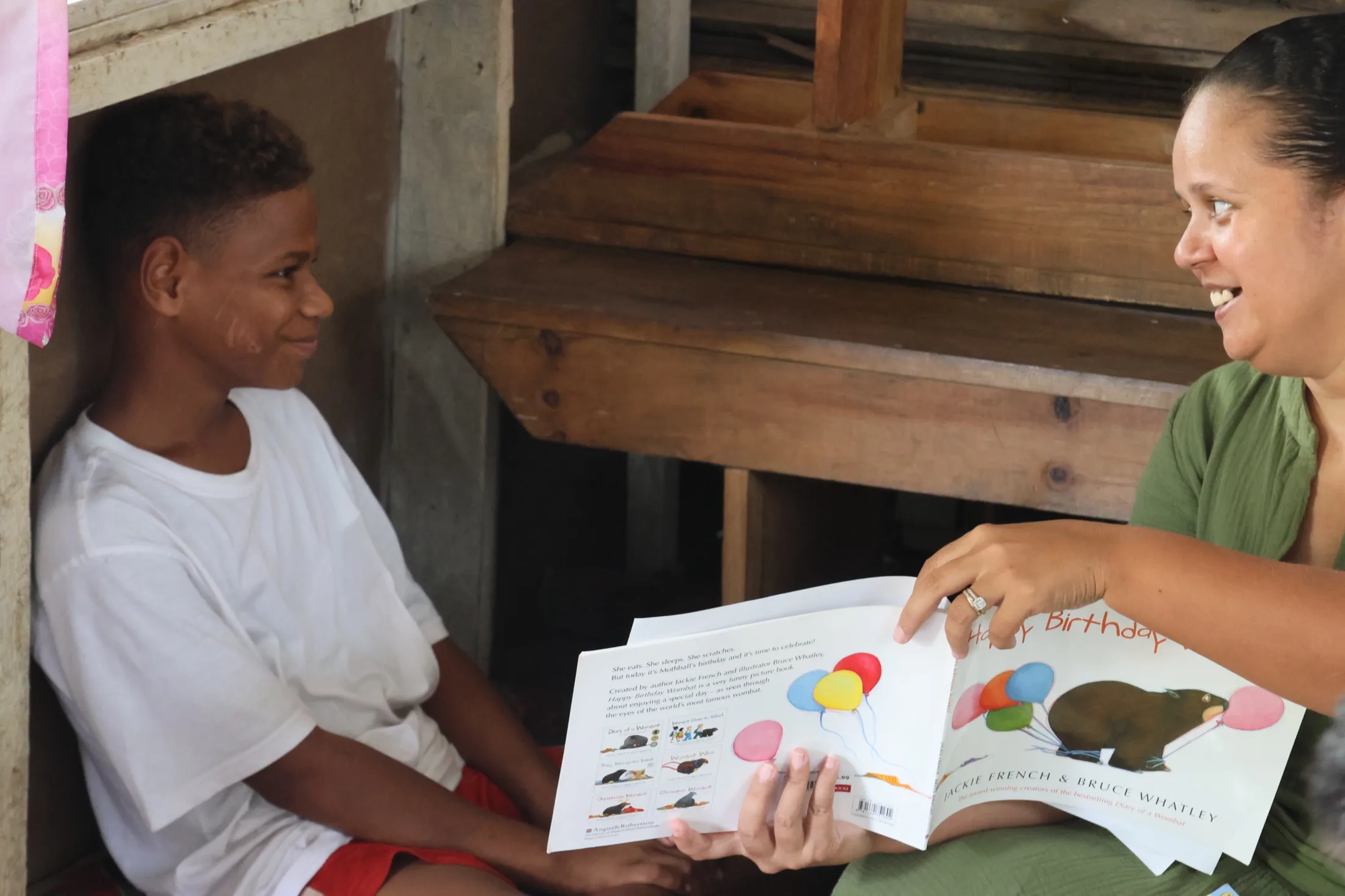 A child looks through an illustrated picture book during a Vunilagi reading session